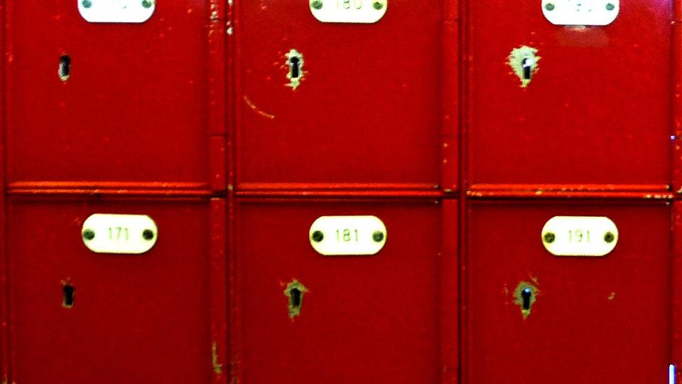 Wall of small red mailboxes with name plates