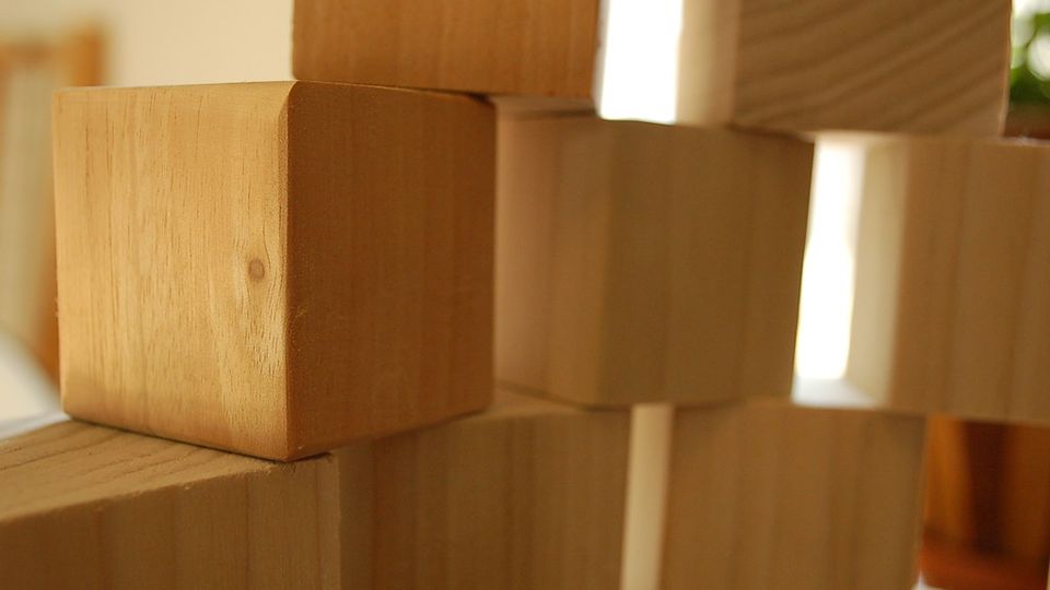 Plain wooden building blocks stacked on top of one another