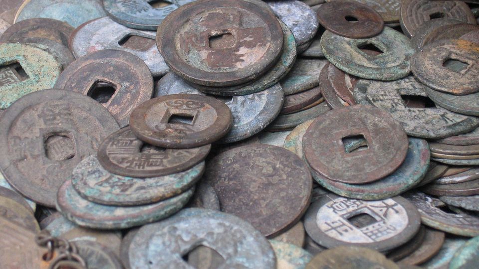 Pile of old bronze coins with square holes