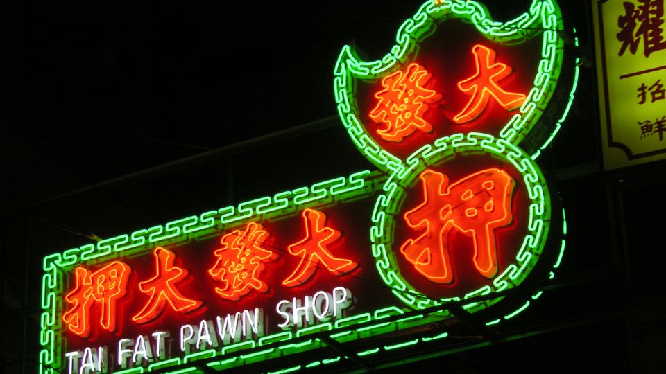 Neon sign of a pawn shop glowing at night