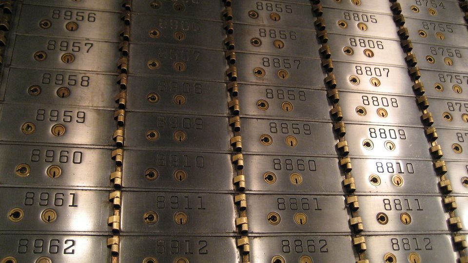Wall of numbered metal safe-deposit boxes in a bank vault