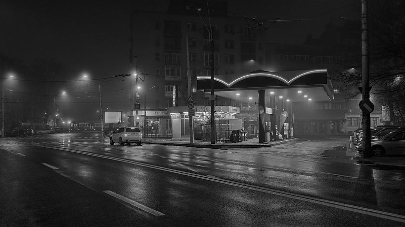 Black-and-white photo of a petrol station at night in fog