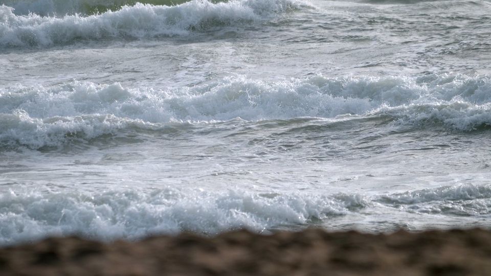 Waves rolling in and breaking on a beach