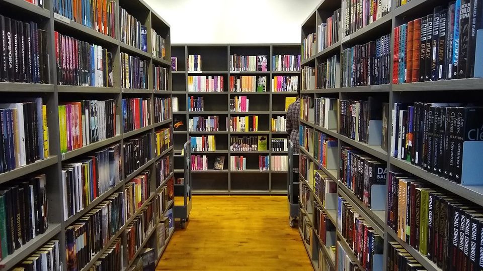 Long aisle between tall bookshelves in a bookshop