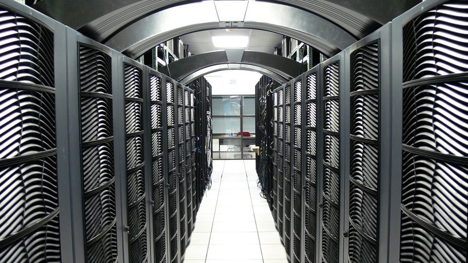 Narrow aisle between rows of server racks in a data centre