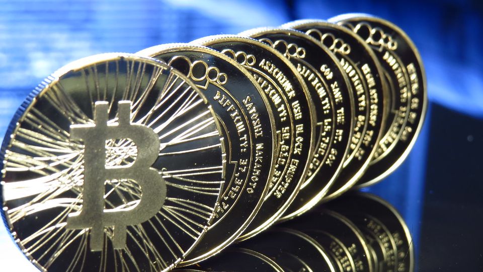 Row of commemorative bitcoin coins lit in blue