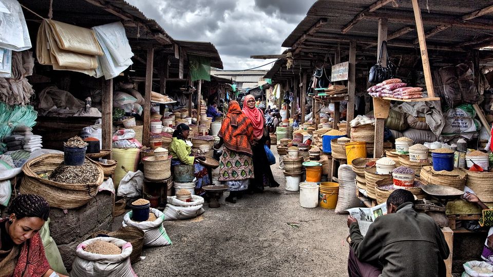 Narrow market lane lined with stalls selling goods