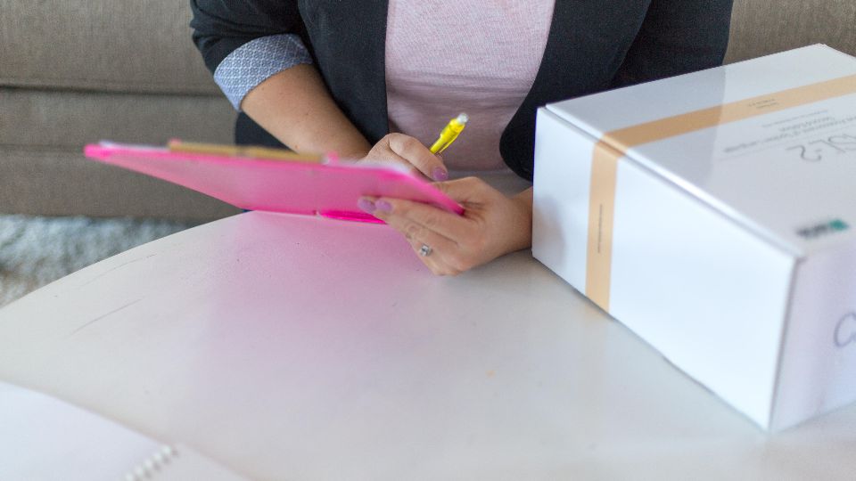 Person ticking items on a checklist on a clipboard