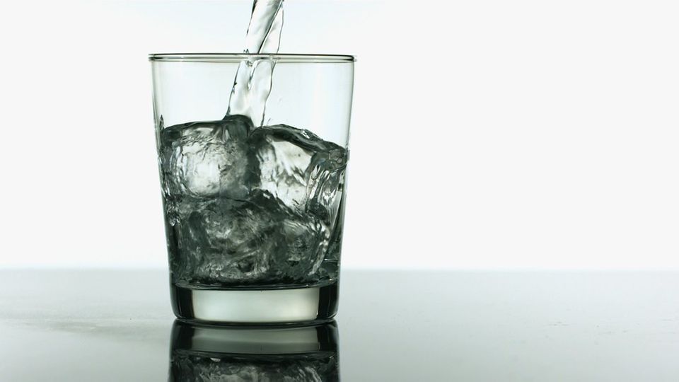 Water being poured into a glass with ice