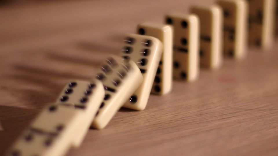Row of dominoes toppling one after another