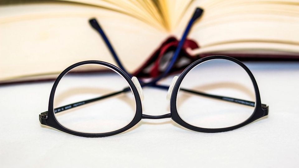 Reading glasses resting on an open book