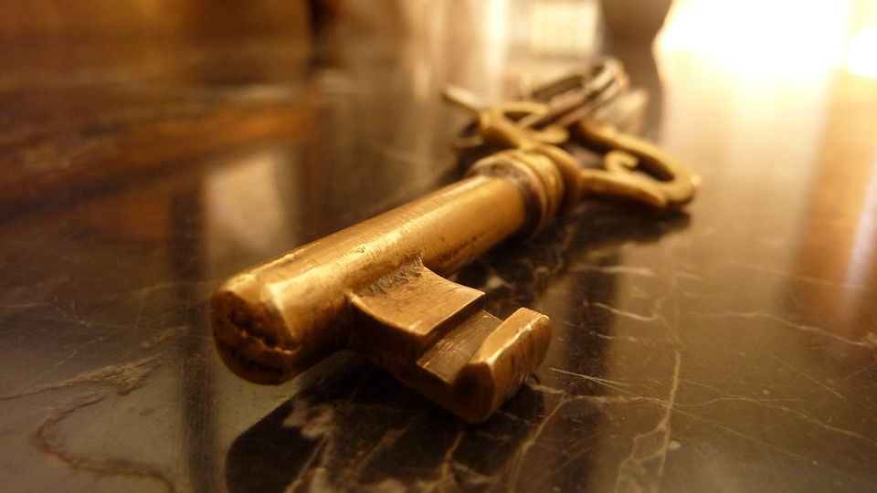 Old brass key lying on a marble surface