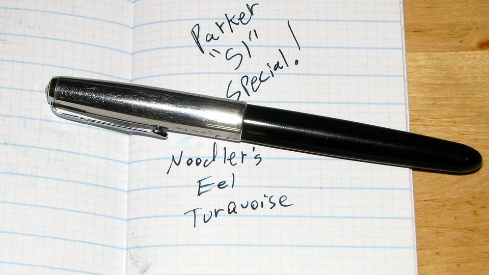 Fountain pen on a notebook page with handwritten words