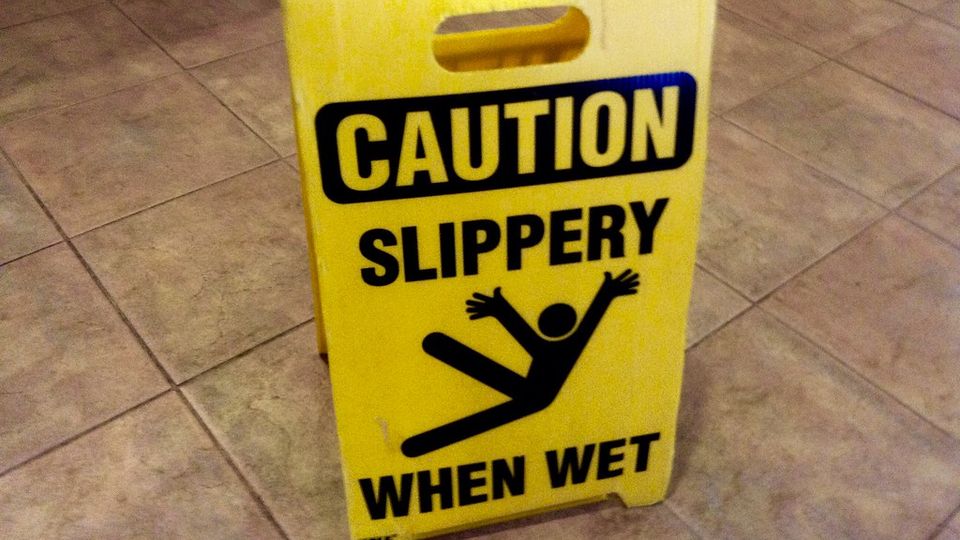 Yellow caution sign warning of a slippery wet floor