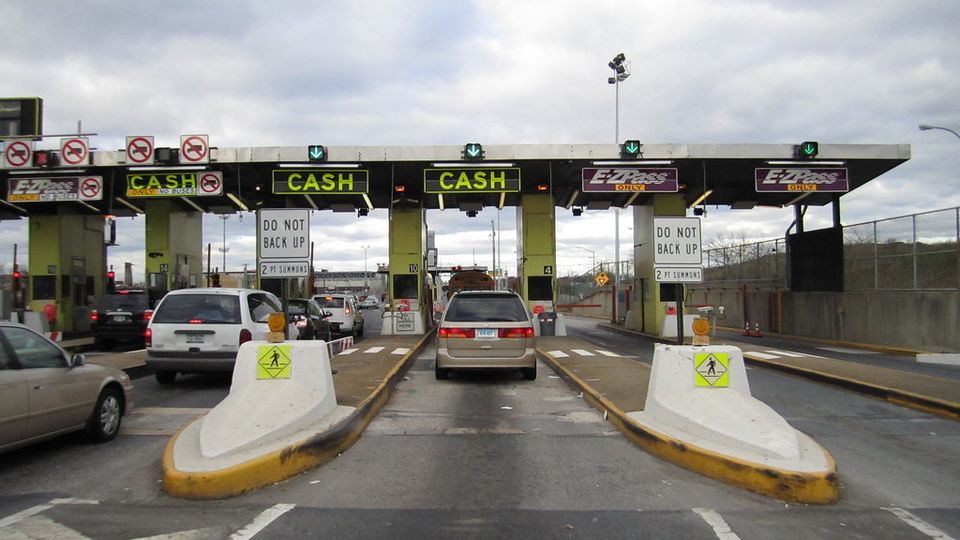 Toll booths across a highway with cars queuing to pay