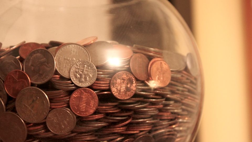 Glass jar filled with loose coins